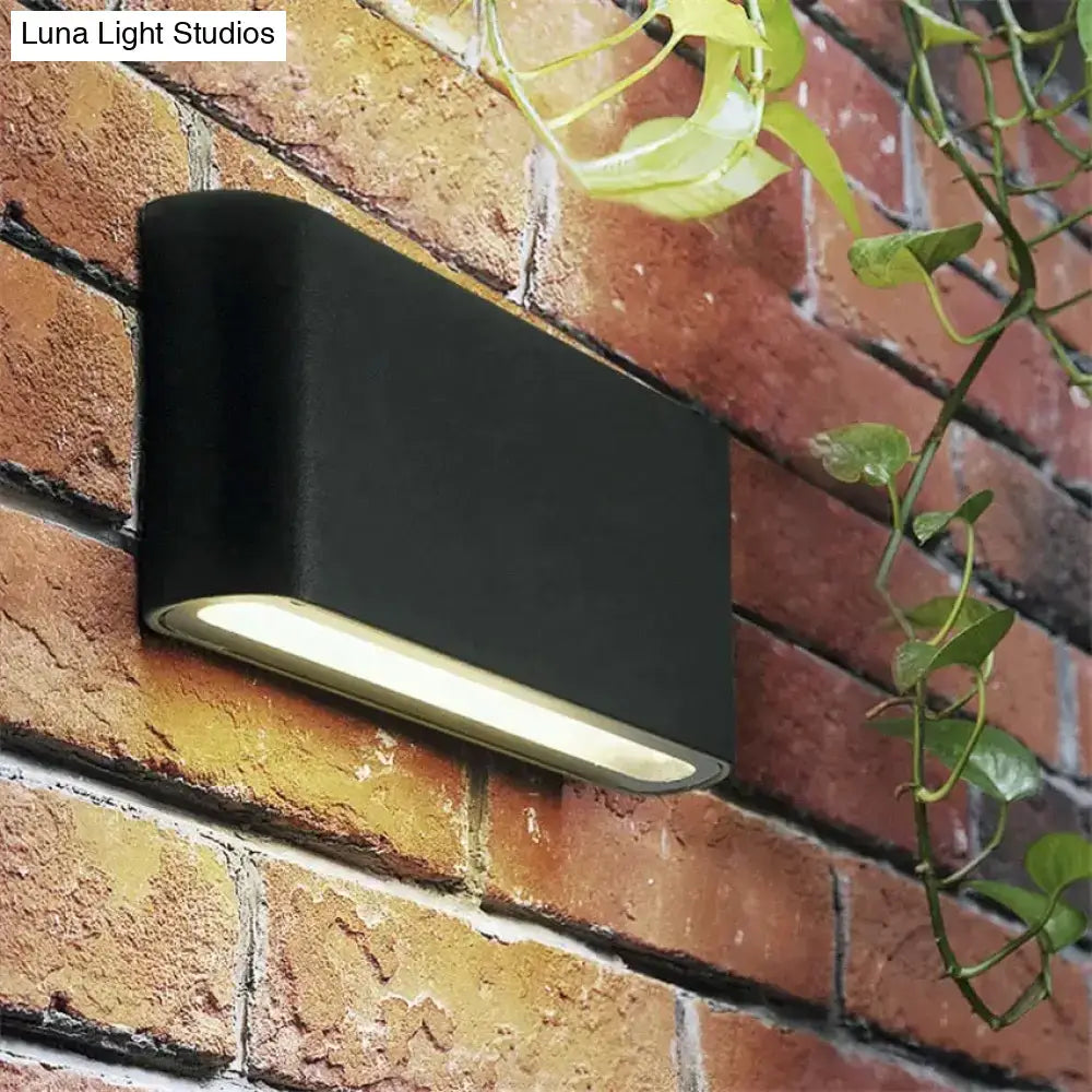 Decorbites black outdoor wall light on brick wall with warm LED glow on Tampa Home & Garden Store