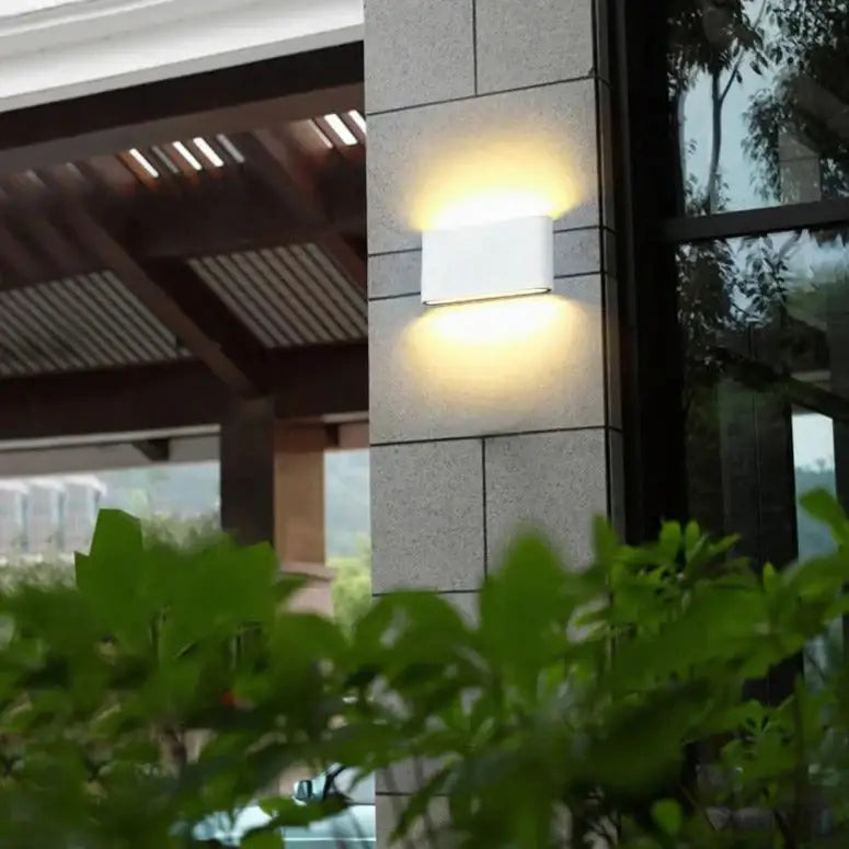 Black outdoor wall light by Decorbites, modern rectangular wall-mount fixture with warm glow on Tampa Home & Garden Store