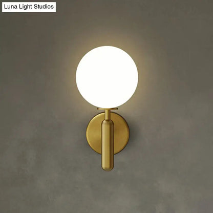 Black glass globe sconce in brass finish with circular backplate by Decorbites on Tampa Home & Garden Store