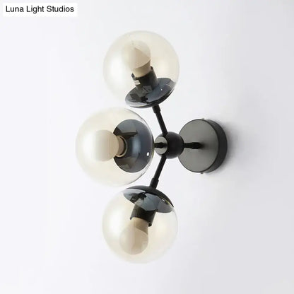Black glass bathroom sconce by Decorbites with three smoky glass globes on black metal mount on Tampa Home & Garden Store