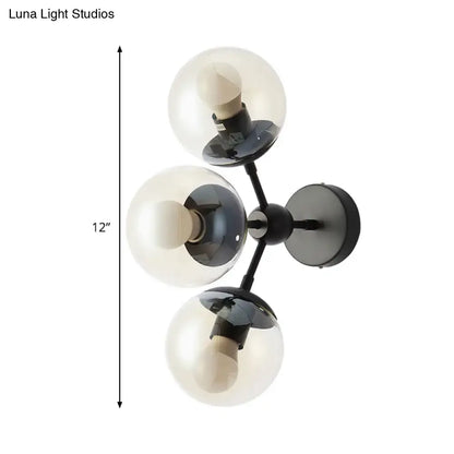Black glass bathroom sconce with three clear glass globes on a black metal mount on Tampa Home & Garden Store