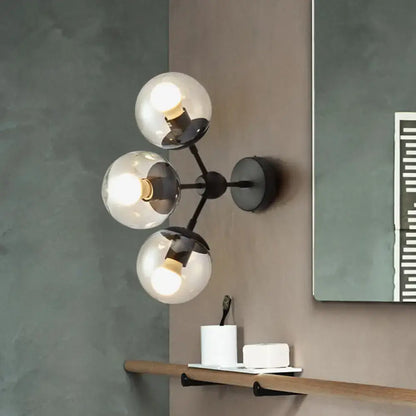 Black glass bathroom sconce by Decorbites with three clear glass globes on Tampa Home & Garden Store