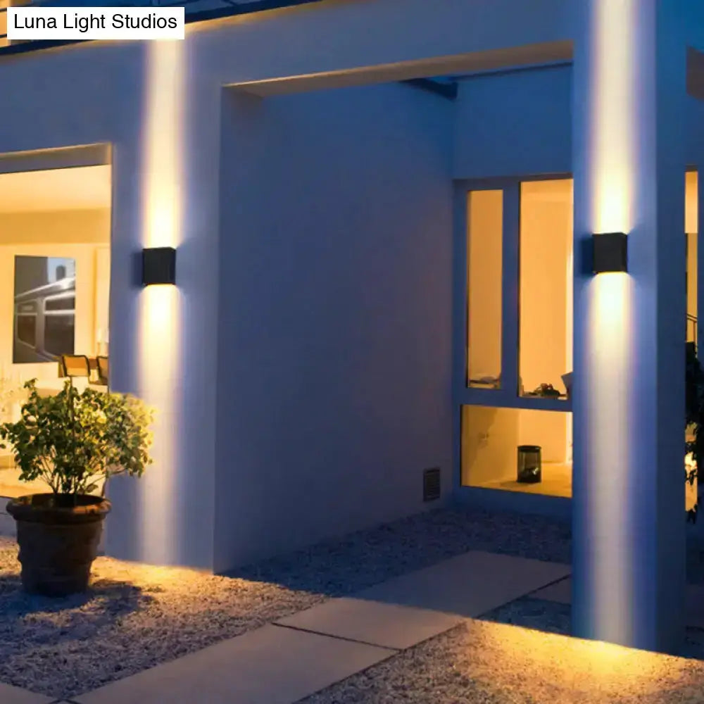 Decorbites modern black metal shade outdoor wall light sconce pair with warm glow by doorway on Tampa Home & Garden Store