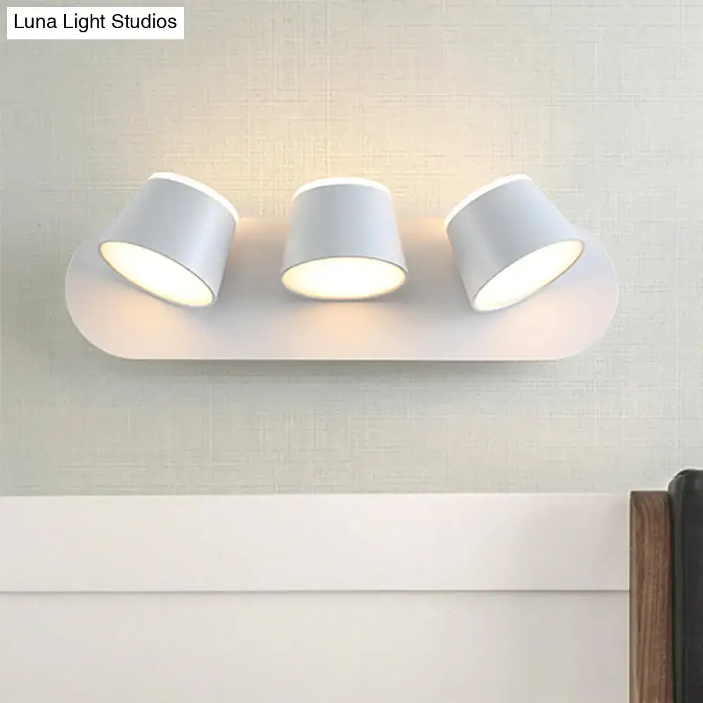 Black metal cone-shade sconce with 3 lights on a rounded white backplate on Tampa Home & Garden Store