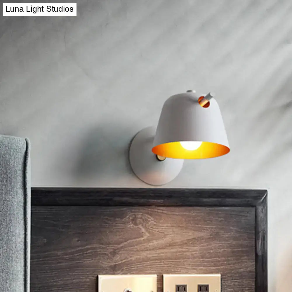 Black metal wall light with white shade and warm yellow interior glow mounted above headboard on Tampa Home & Garden Store