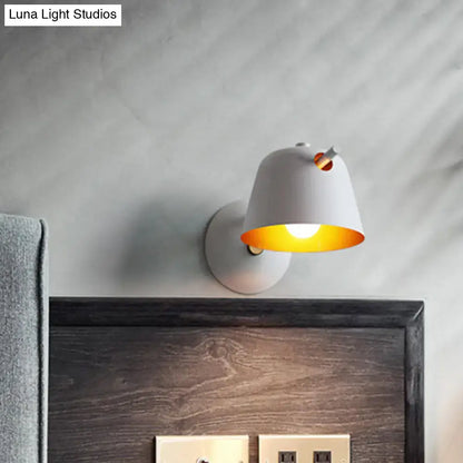 Black metal wall light with white shade and warm yellow interior glow mounted above headboard on Tampa Home & Garden Store
