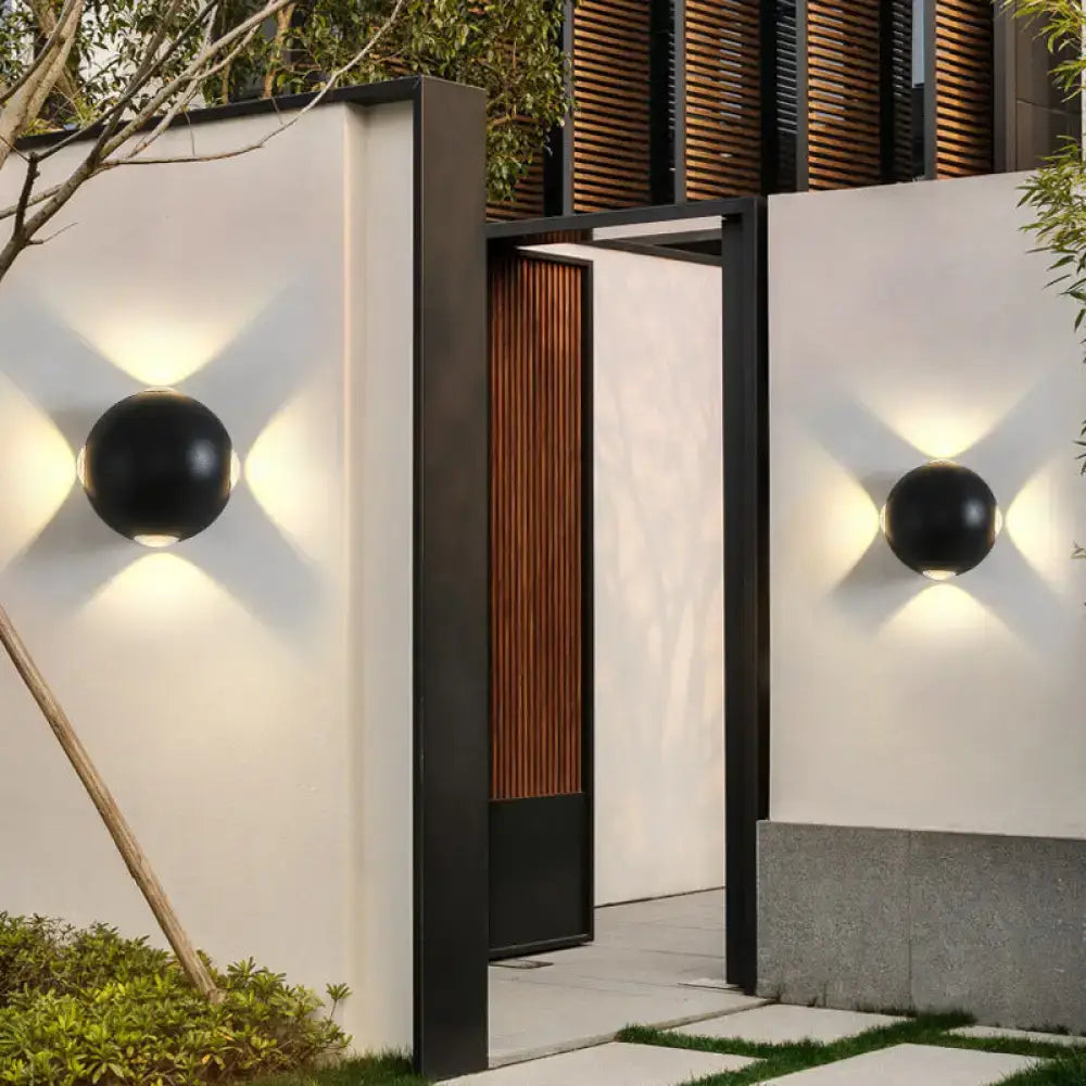 Black spherical outdoor wall sconces by Decorbites, pair on white walls with warm glow on Tampa Home & Garden Store