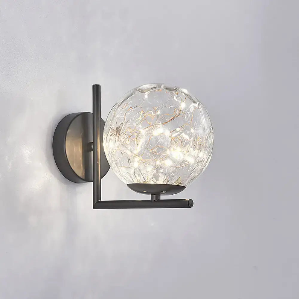 Black globe wall sconce by Decorbites, clear glass orb with gold accents on dark mount on Tampa Home & Garden Store