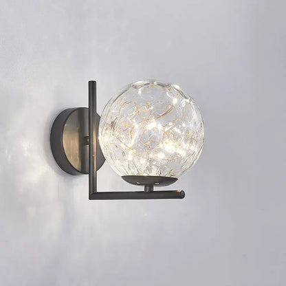 Black globe wall sconce by Decorbites, clear glass orb with gold accents on dark mount on Tampa Home & Garden Store