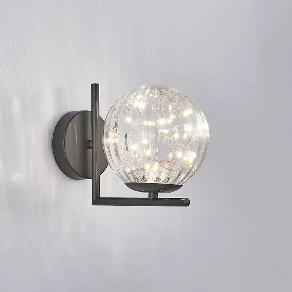 Black globe wall sconce with clear glass orb and warm LED filament lights on Tampa Home & Garden Store