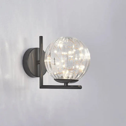 Black globe wall sconce with clear glass orb and warm LED filament lights on Tampa Home & Garden Store
