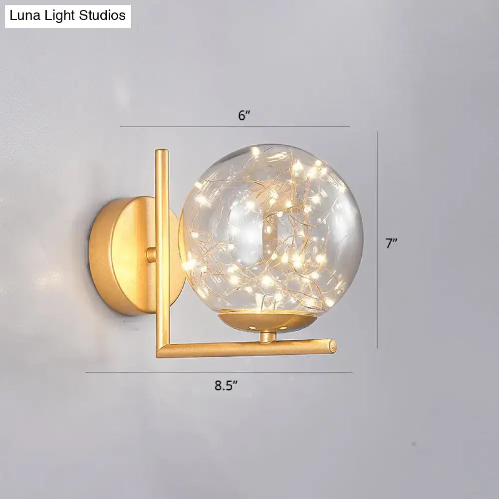 Decorbites Black Globe Wall Sconce with gold-tone arm and clear glass globe filled with warm fairy lights on Tampa Home & Garden Store