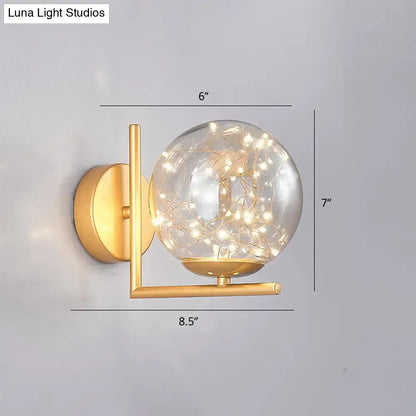 Decorbites Black Globe Wall Sconce with gold-tone arm and clear glass globe filled with warm fairy lights on Tampa Home & Garden Store