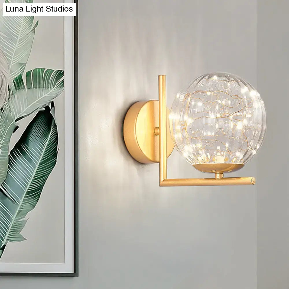 Black Globe Wall Sconce, Luna Light Studios, brass finish, glass globe with warm string lights on Tampa Home & Garden Store