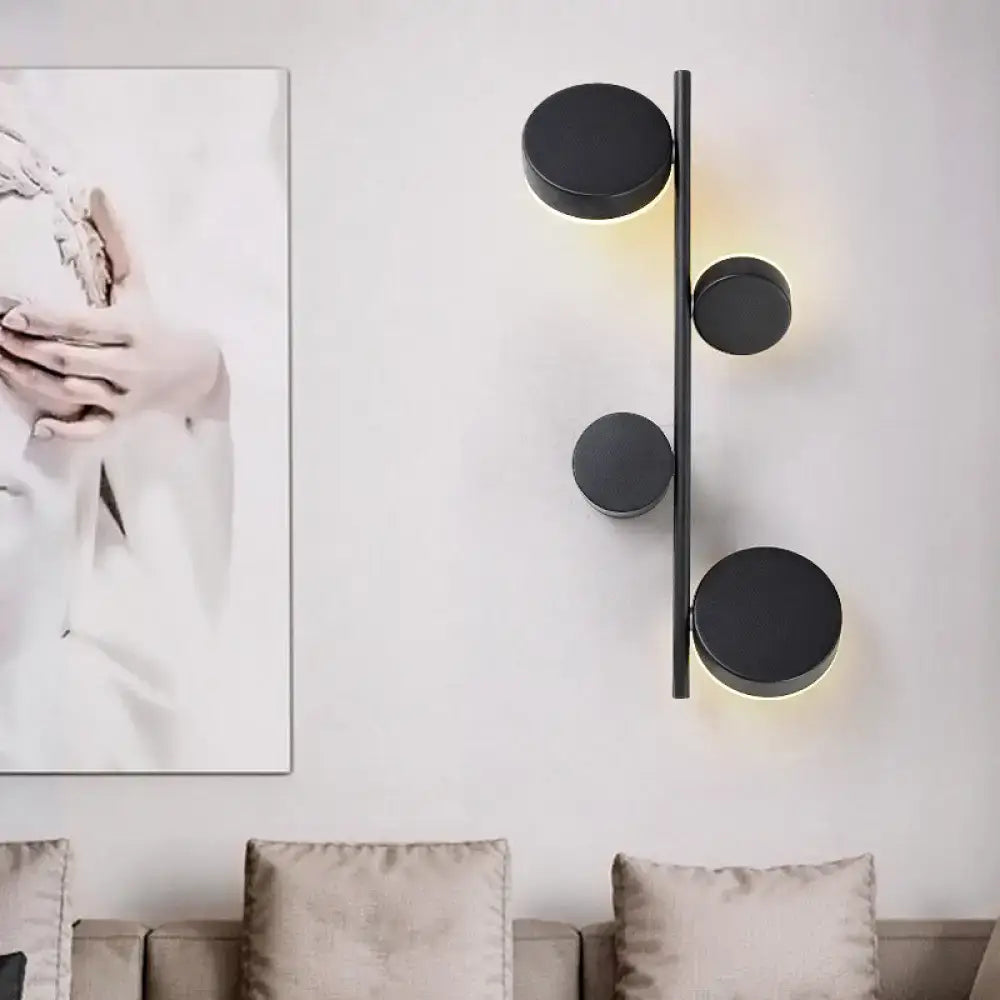 Black Circle Wall Sconce by Decorbites, matte black discs on a vertical bar with warm glow on Tampa Home & Garden Store