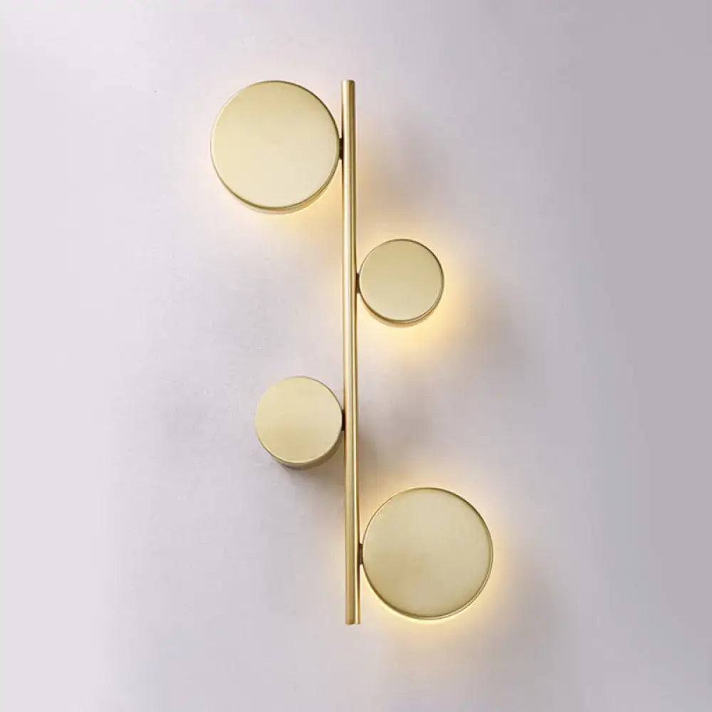Black Circle Wall Sconce with four discs on a vertical gold bar, warm glow on Tampa Home & Garden Store