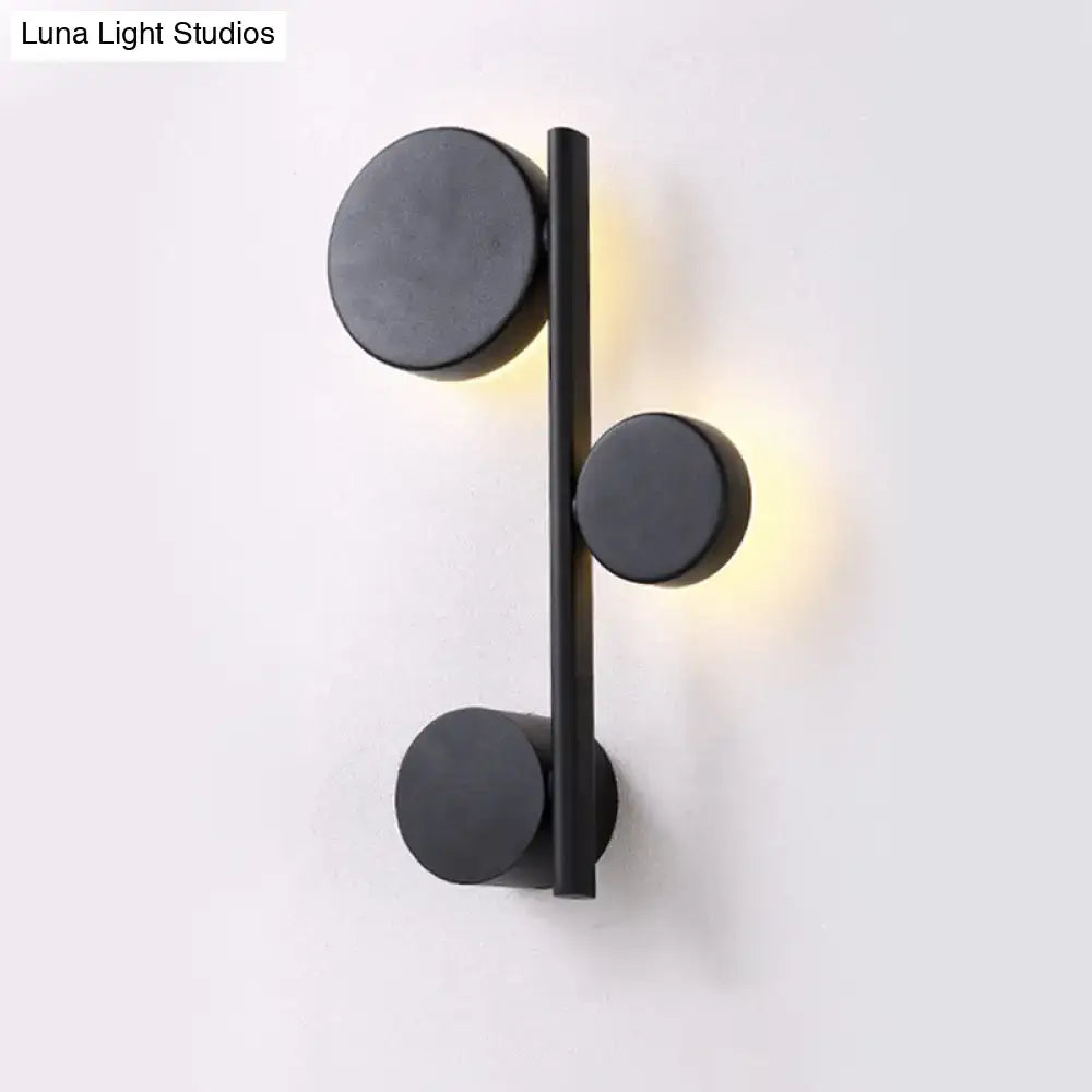 Black circle wall sconce by Decorbites with vertical bar and three round discs, warm glow on Tampa Home & Garden Store