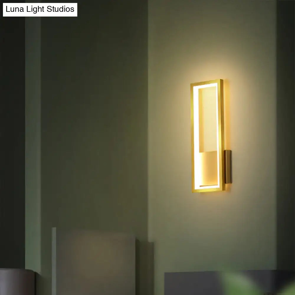 Rectangular gold LED wall sconce with inner frame and warm glow mounted on a foyer wall on Tampa Home & Garden Store