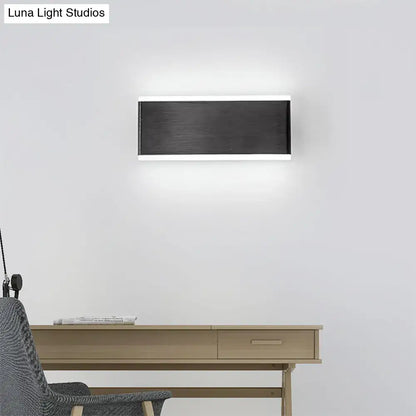 Black industrial 4.5-inch cast iron sconce by Decorbites on white wall above a light wood desk on Tampa Home & Garden Store