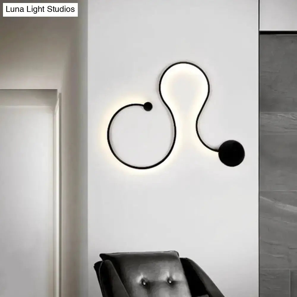 Wall lamp sconce in black by Decorbites with abstract curved line design and white glow on Tampa Home & Garden Store