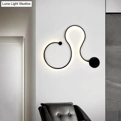 Wall lamp sconce in black by Decorbites with abstract curved line design and white glow on Tampa Home & Garden Store