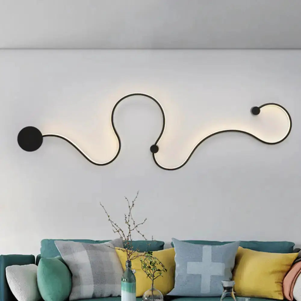 Decorbites modern black minimalist wall lamp featuring a flow LED light curve above teal sofa on Tampa Home & Garden Store