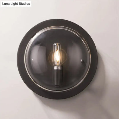 Black metal wall sconce with round crystal shade and exposed Edison bulb on Tampa Home & Garden Store
