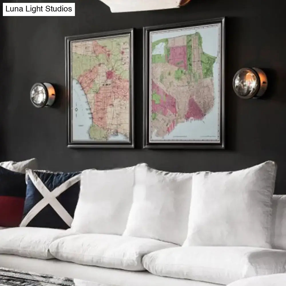 Black metal wall sconces with crystal shade, a pair beside two framed maps above a white sofa on Tampa Home & Garden Store