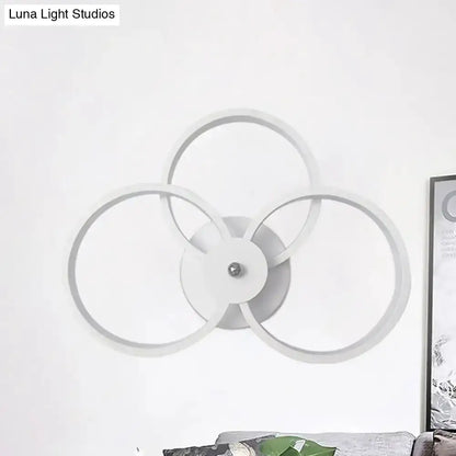 Modern black and silver LED hoop wall lamp with three interlocking rings on a white wall on Tampa Home & Garden Store