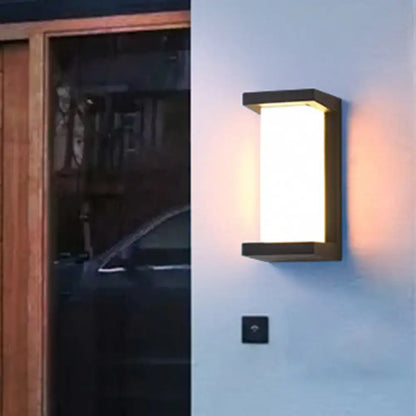 Black Decorbites sound-activated sconce wall light with frosted panel on blue exterior wall on Tampa Home & Garden Store