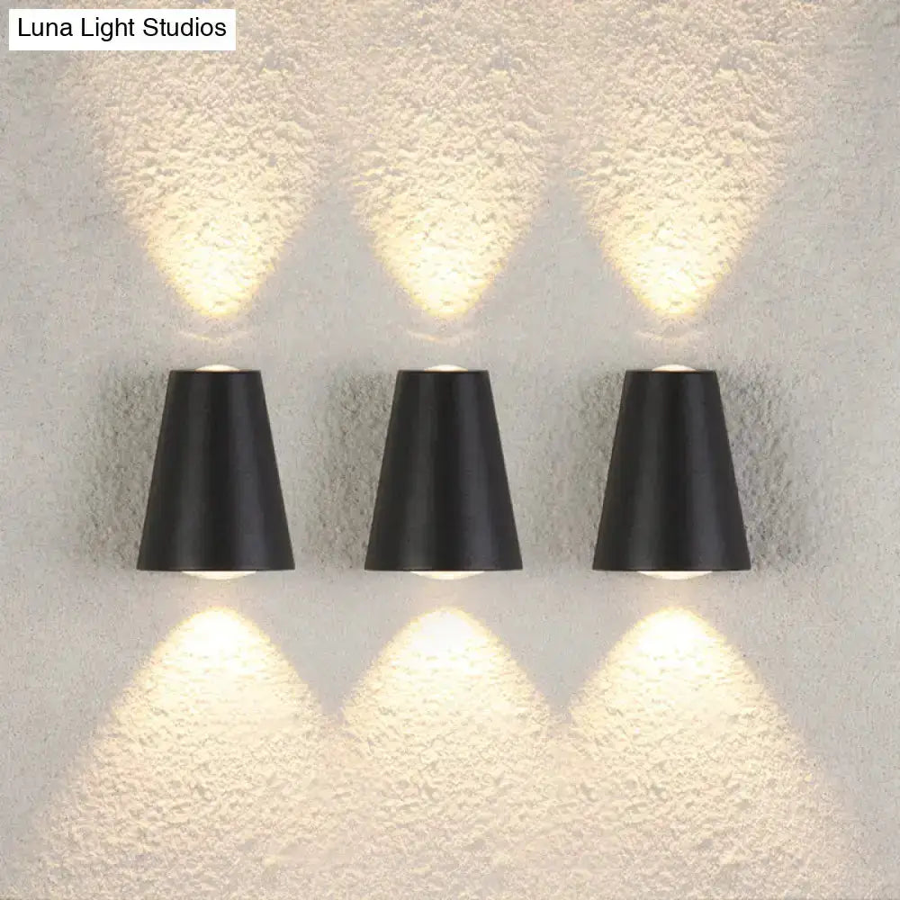 Three black trapezoid garden wall lights by Decorbites, uplight and downlight on textured wall on Tampa Home & Garden Store
