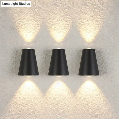 Three black trapezoid garden wall lights by Decorbites, uplight and downlight on textured wall on Tampa Home & Garden Store