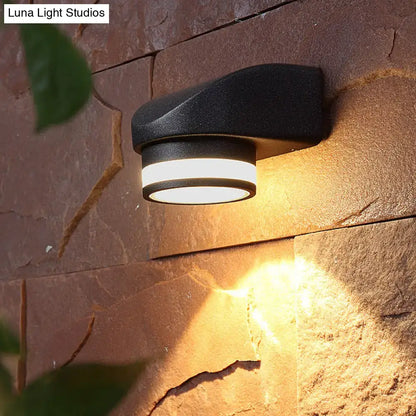 Black tubular wall sconce by Decorbites, matte black metal wall light on a stone wall on Tampa Home & Garden Store