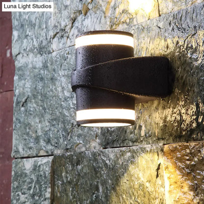 Black tubular wall sconce with wrap strap on stone wall on Tampa Home & Garden Store