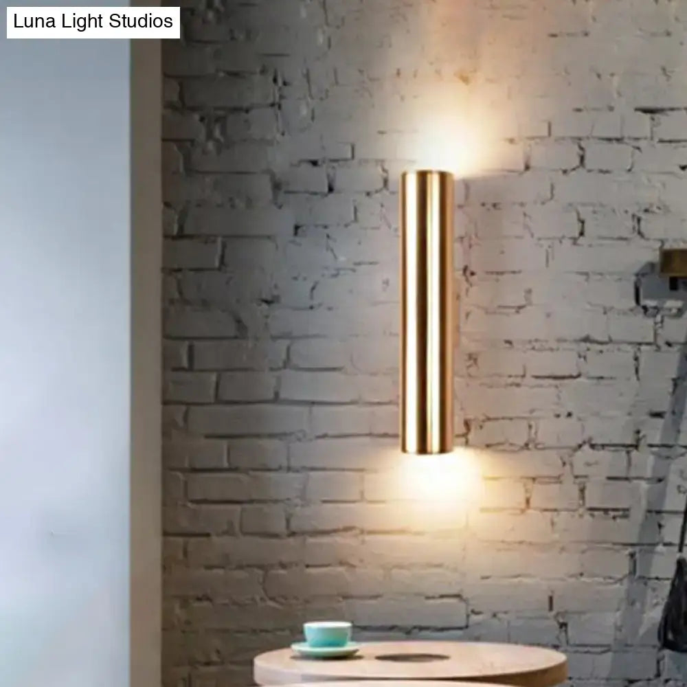 Decorbites black tubular wall lamp mounted on brick wall with warm ambient glow on Tampa Home & Garden Store