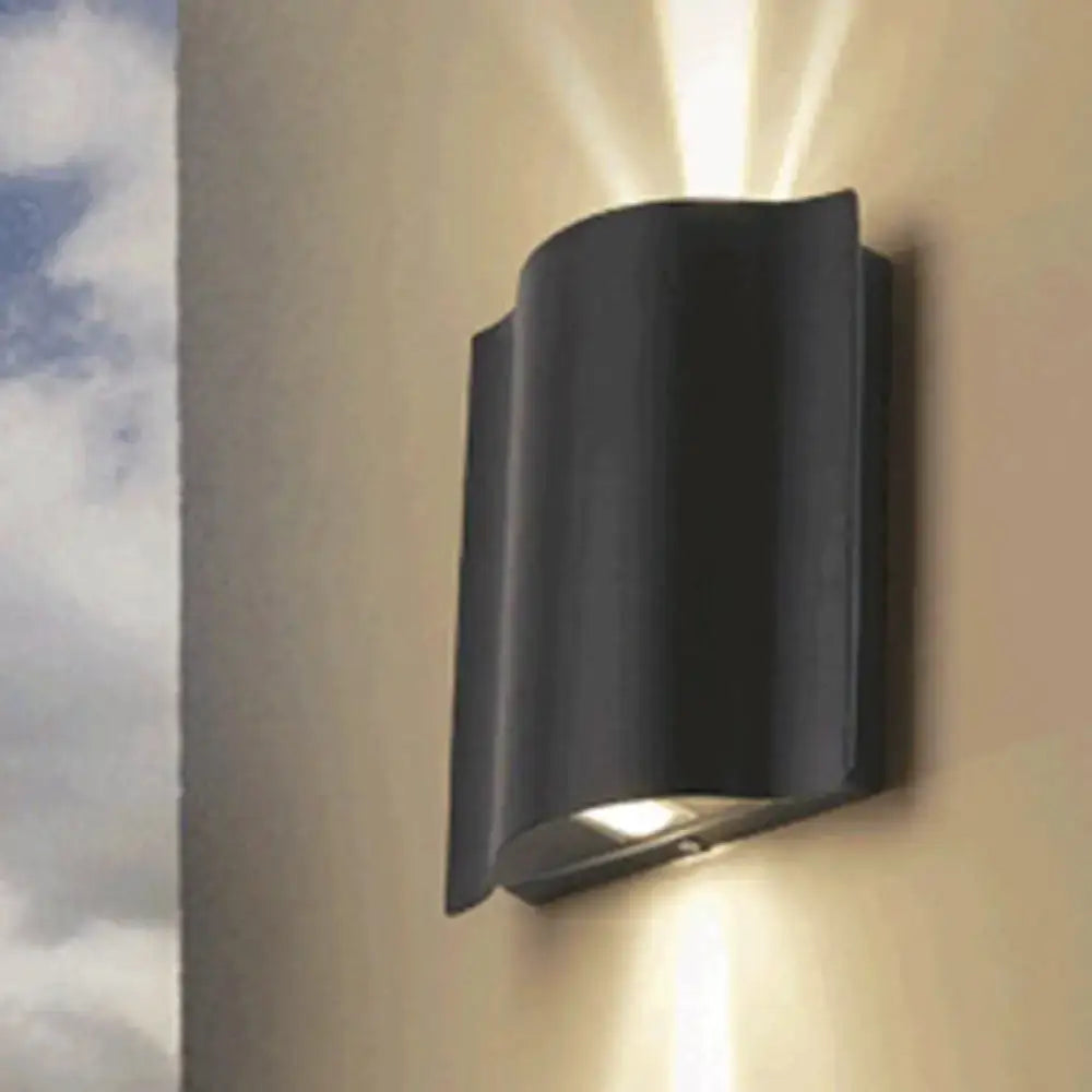 Black wavy wall sconce by Decorbites; black metal wall light casting uplight and downlight on Tampa Home & Garden Store