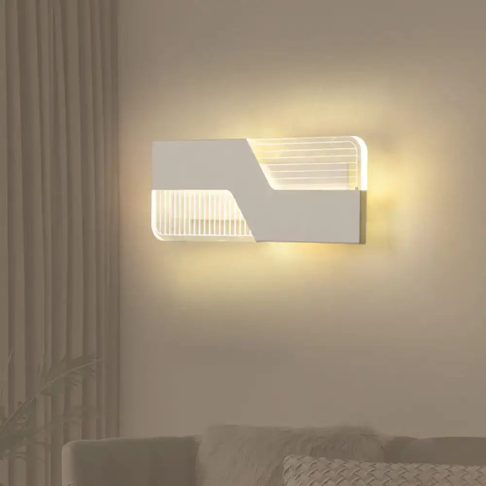 White angular wall sconce with geometric cutouts by Decorbites emitting warm light on Tampa Home & Garden Store