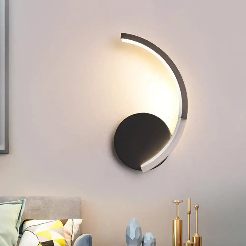 Decorbites curved LED wall sconce with black round base and illuminated arc light on Tampa Home & Garden Store