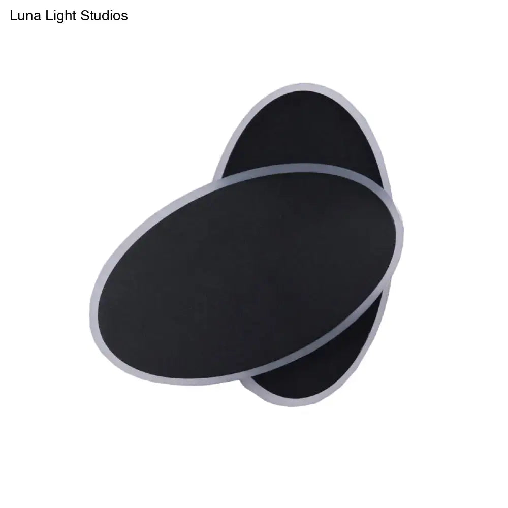 Black oval wall sconce with layered overlapping panels and silver trim on Tampa Home & Garden Store