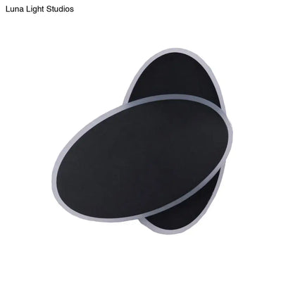 Black oval wall sconce with layered overlapping panels and silver trim on Tampa Home & Garden Store