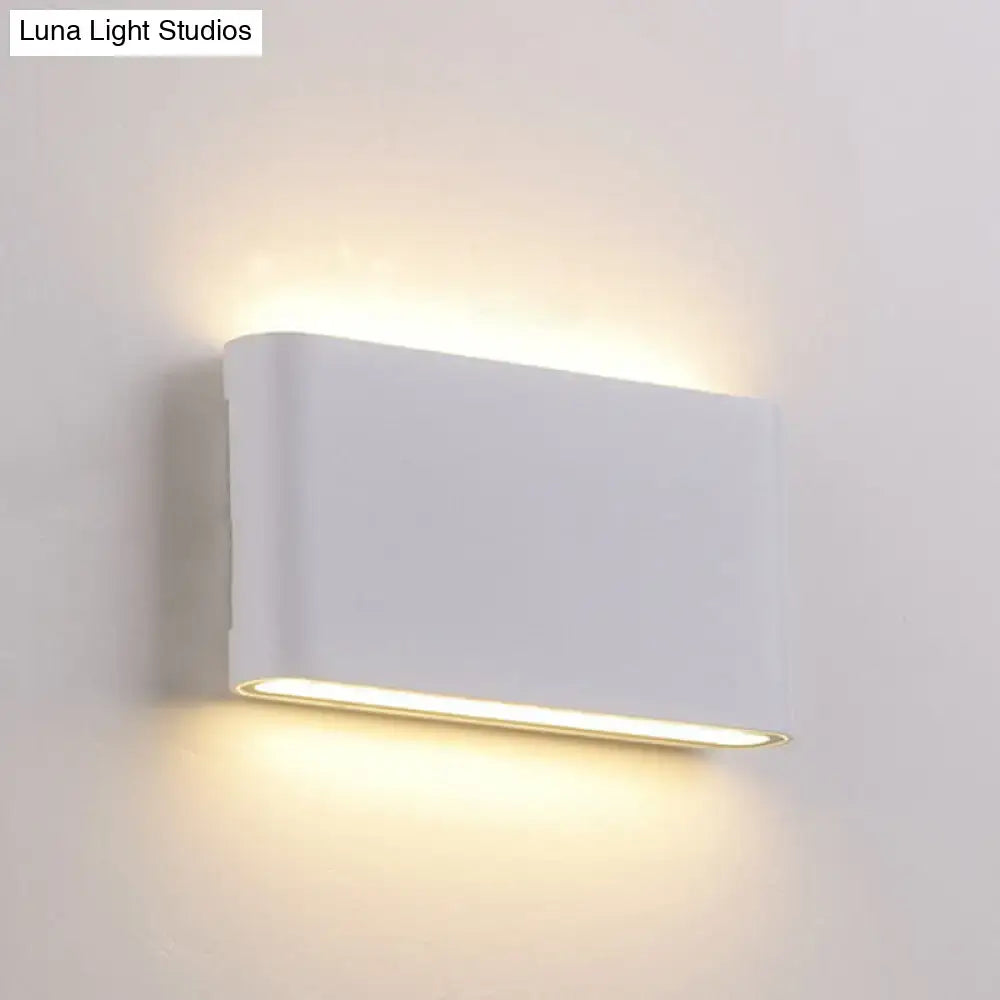 Black oblong wall lamp by Decorbites with warm upward and downward glow on white wall on Tampa Home & Garden Store