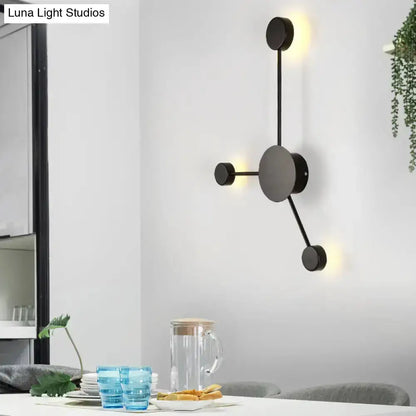 Decorbites modern black metal geometric wall sconce with circular discs and warm LED glow on Tampa Home & Garden Store