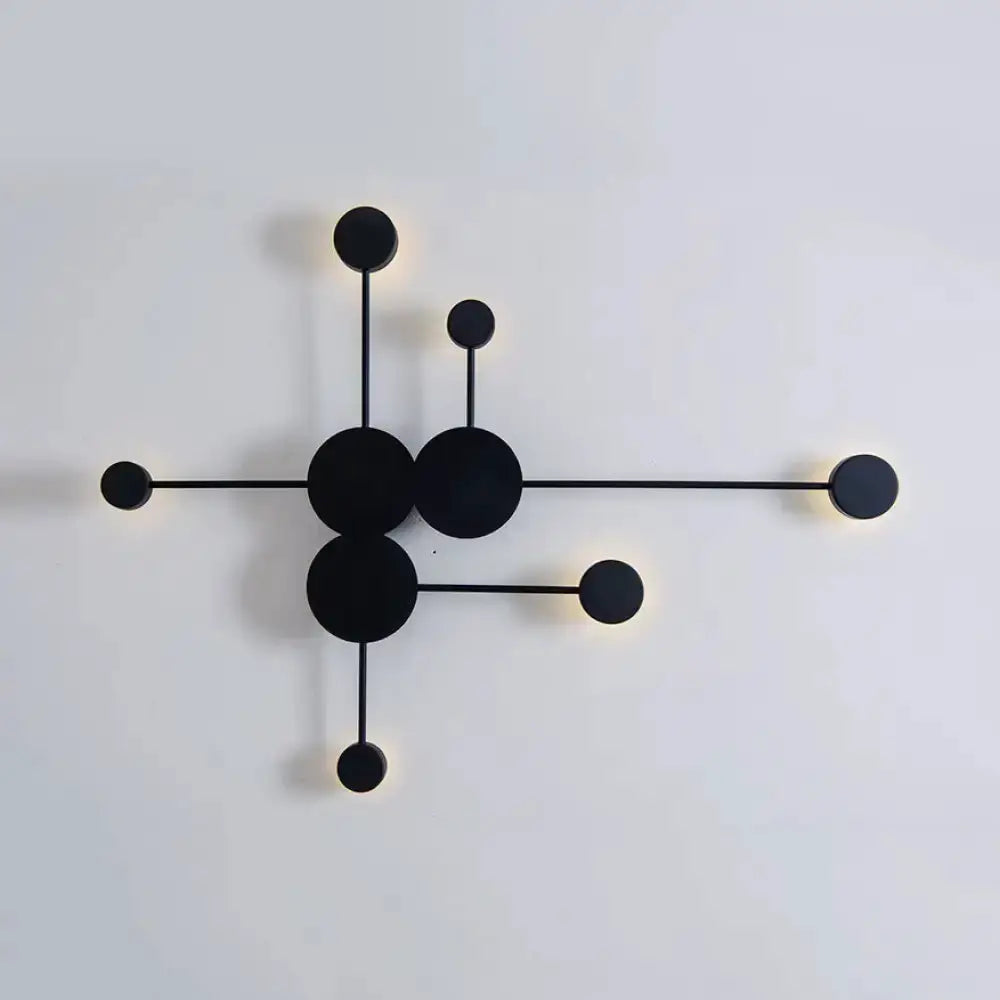 Modern black metal wall sconce with circular discs by Decorbites, warm glow at ends on Tampa Home & Garden Store