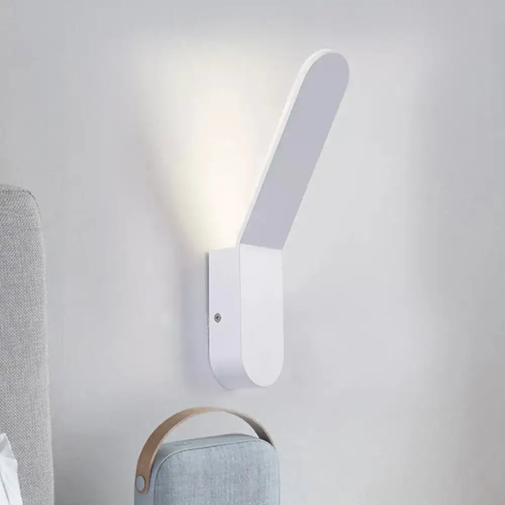 White oval metal corridor wall sconce casts upward light beside a gray sofa on Tampa Home & Garden Store