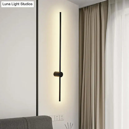 Modern black LED metal wall sconce with vertical bar and central mount, warm backlight on Tampa Home & Garden Store