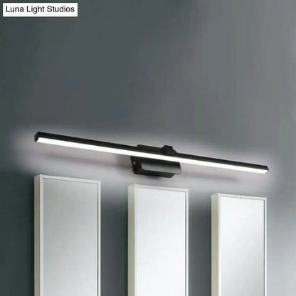 Black iron vanity light bar with LED, mounted above three white bathroom cabinets on Tampa Home & Garden Store
