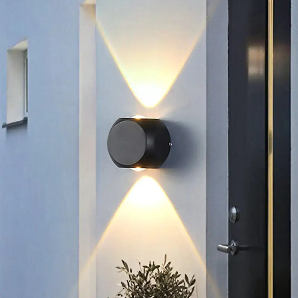 Decorbites Mini Cube Wall Sconce, black cylindrical wall light with up-down glow on white wall on Tampa Home & Garden Store