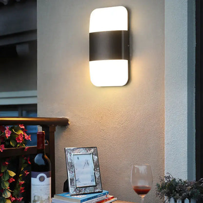 Black rectangle cast iron wall sconce with two white illuminated panels warm glow on Tampa Home & Garden Store