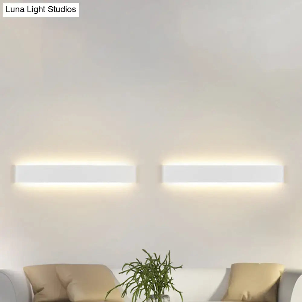Black Rectangular Wall Lamp pair with warm backlit glow on a white living room wall Decorbites on Tampa Home & Garden Store