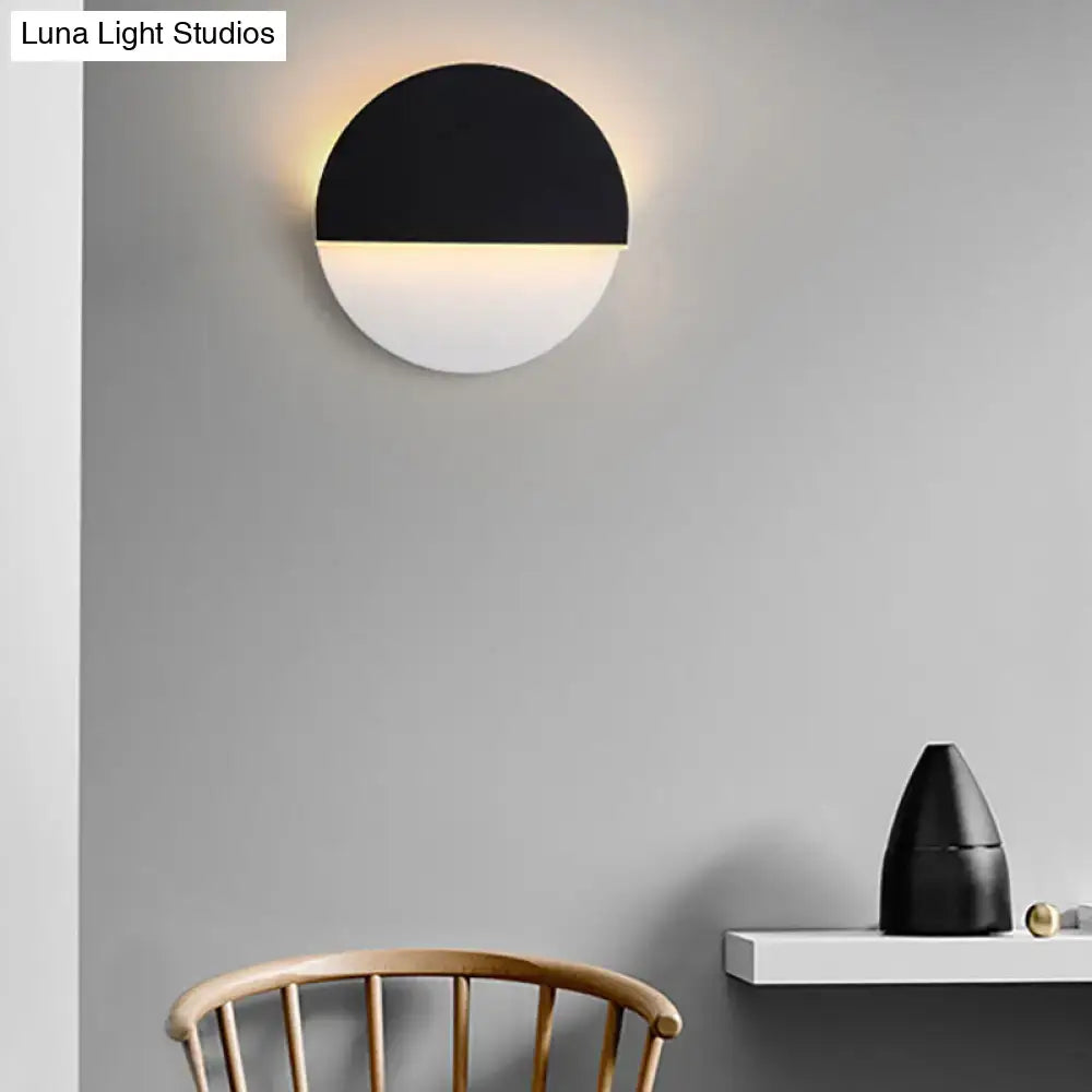 Black acrylic minimalist LED wall lamp with black top half and glowing white bottom on Tampa Home & Garden Store